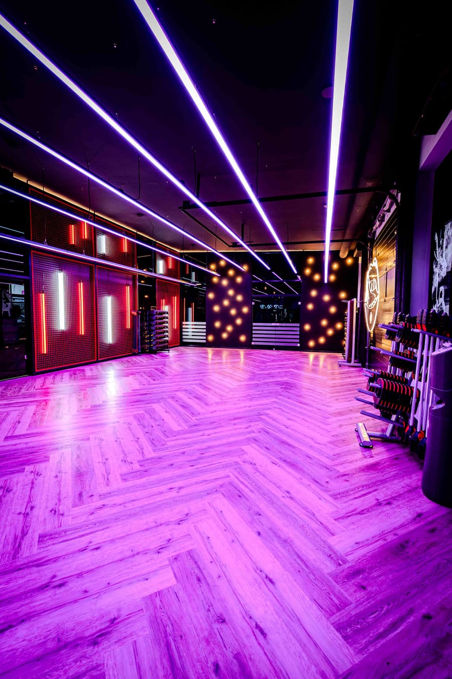 Fitnessstudio mit pinkem Neonlicht und Fischgrät-Boden – Beispiel unserer Foto- und Videoproduktion