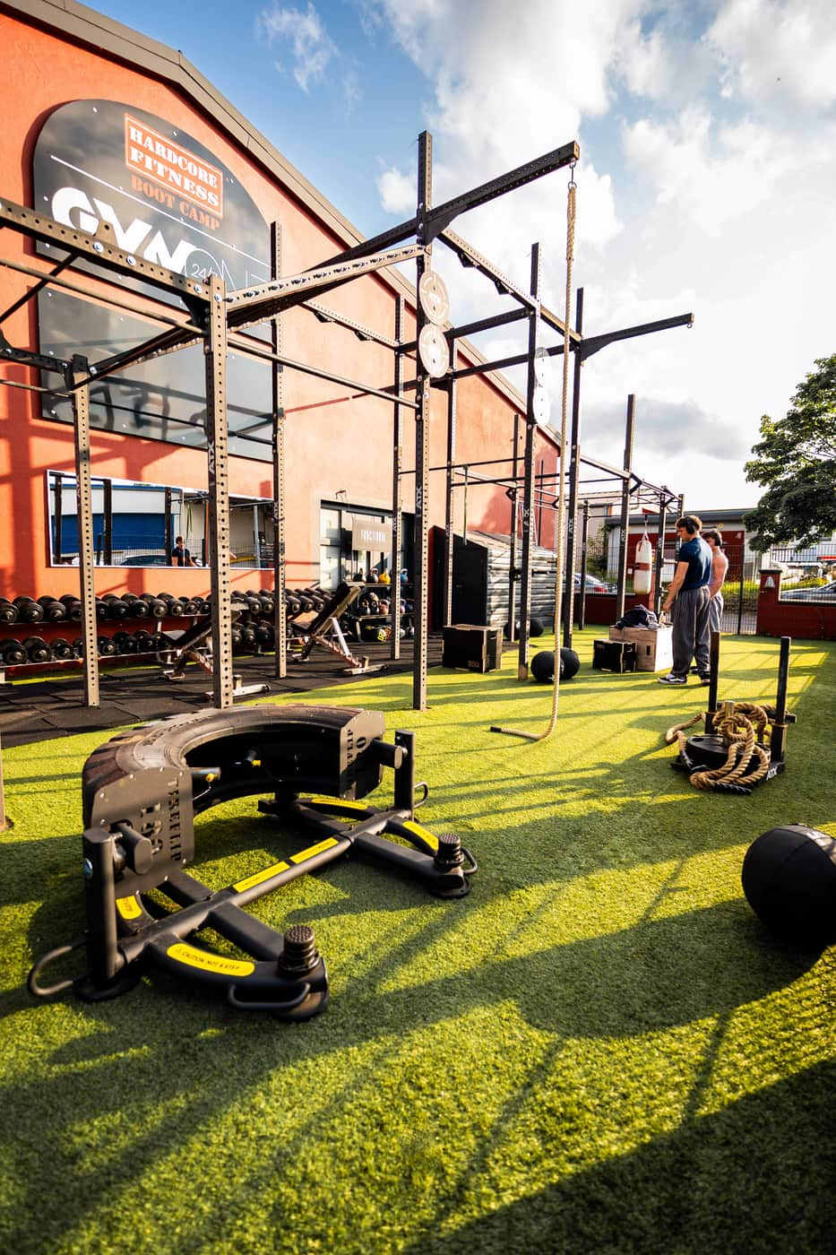 Outdoor-Trainingsbereich eines Hardcore Fitness Boot Camps mit Functional-Equipment auf Kunstrasen